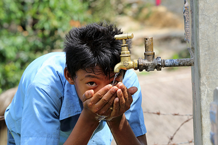 A boy drinks water from a tap stand at his school in Puware Shikhar, Udayapur District, Nepal © Jim Holmes / AusAID